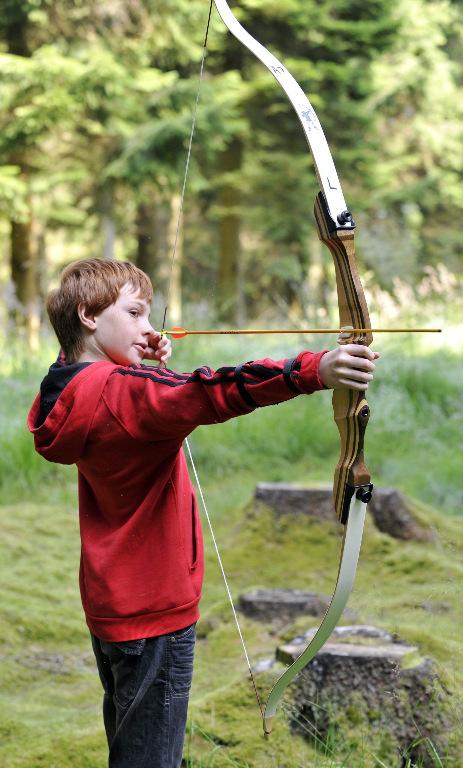 Archery at Kielder Waterside. Young boy holding huge bow and arrow.